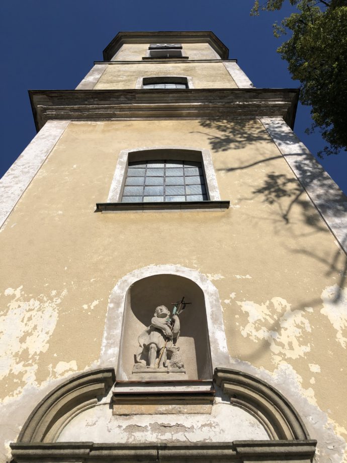 Kostel sv. Jana Křtitele v Mladkově, nad portálem je v nice umístěna barokní socha patrona kostela z roku 1756