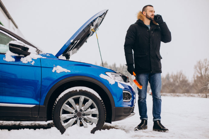 Man standing by broken car and calling for help